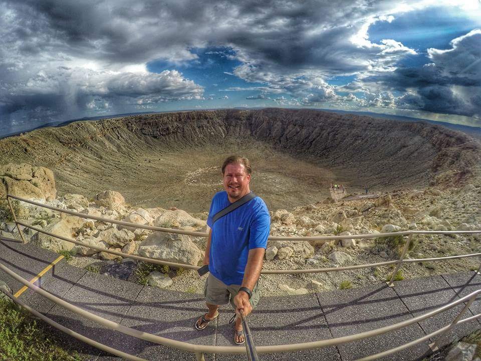Greg Berndt from Flip Flop Wanderer standing in front of the Meteor Crater in Arizona. This image is on his About Page.