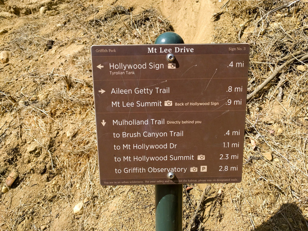 Sign with miles on the trail